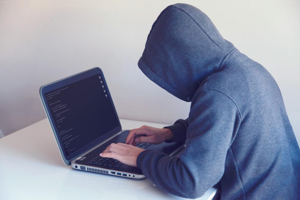 Hacker in a hoodie at a computer